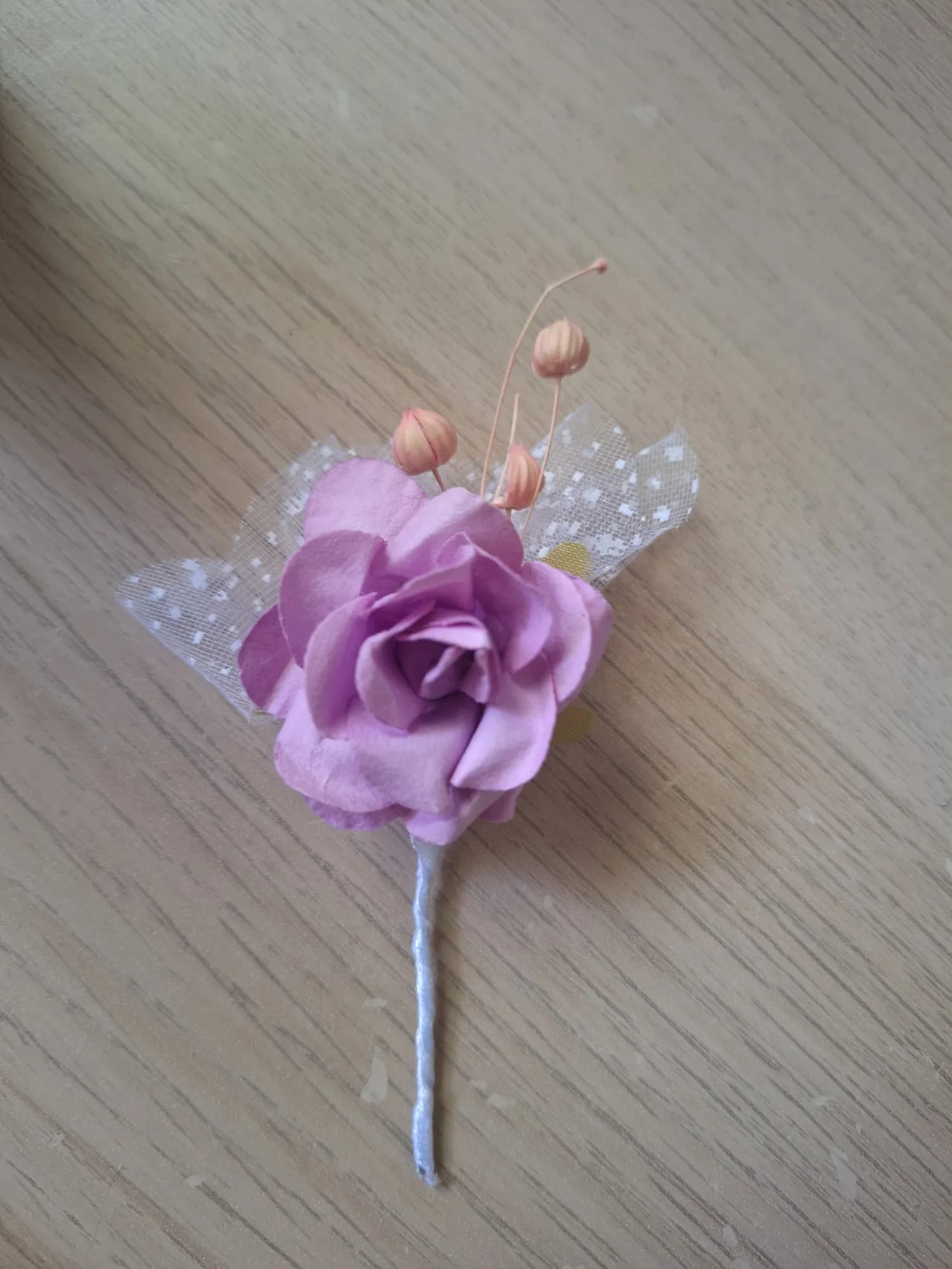 Boutonniere with a dusty rose paper flower and polka-dot tulle.